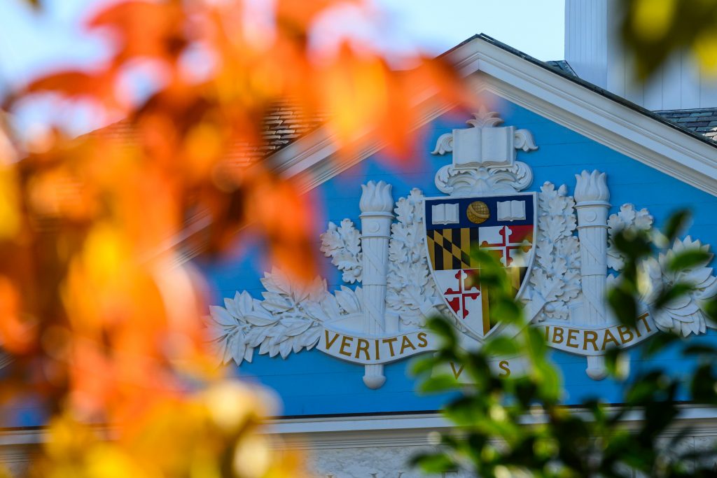 Fall leaves in the foreground with University building in the background