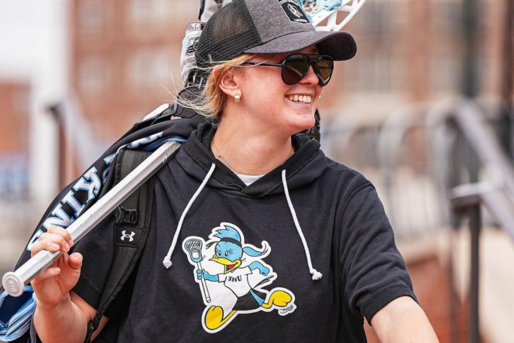 Women's lacrosse player wearing a shirt with a NAG Jay on it