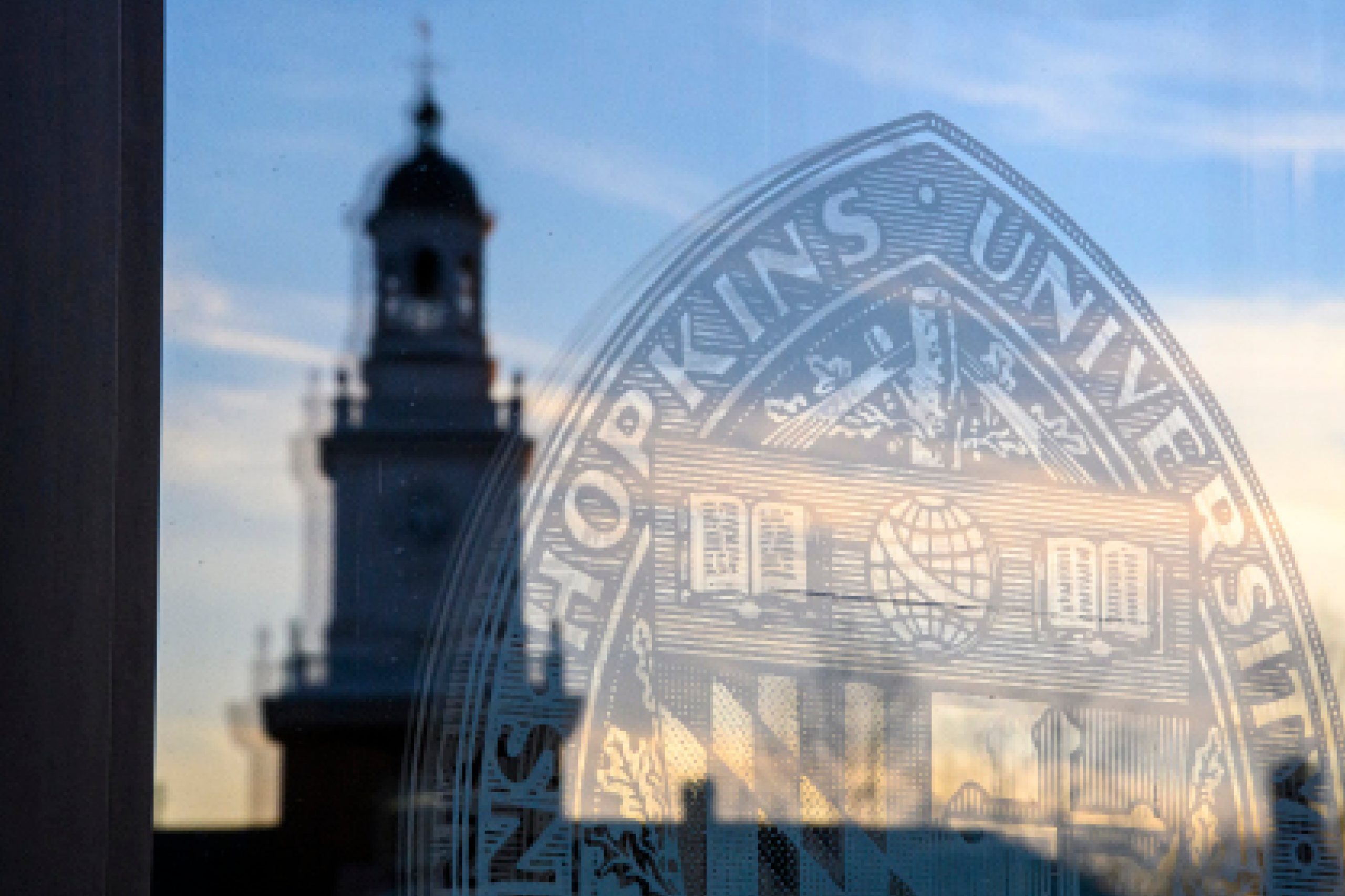 Hopkins seal etched in glass with abstract reflection