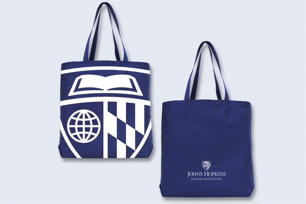 University shield on the front of a tote bag, with the logo on the back.