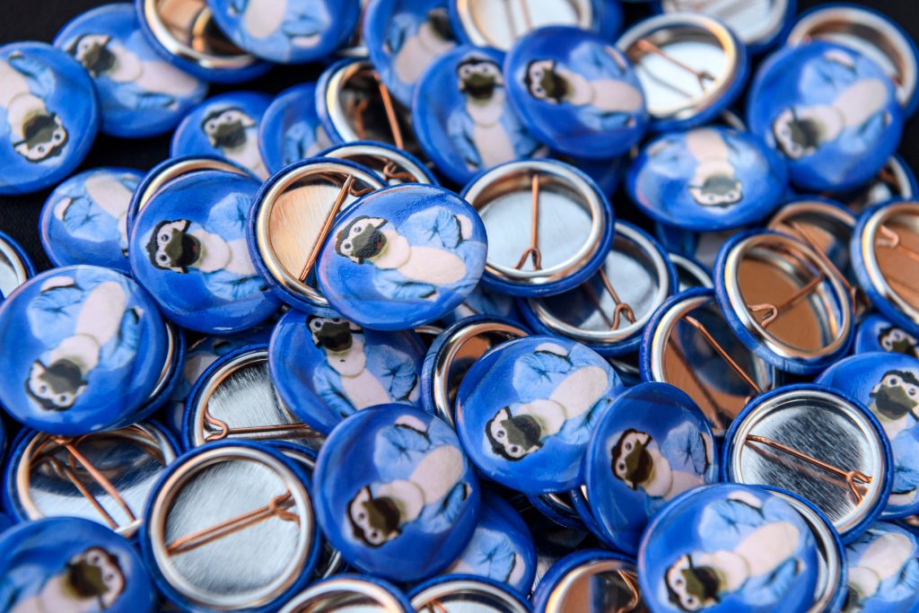 Pile of circle buttons with the Blue Jay mascot printed on them.