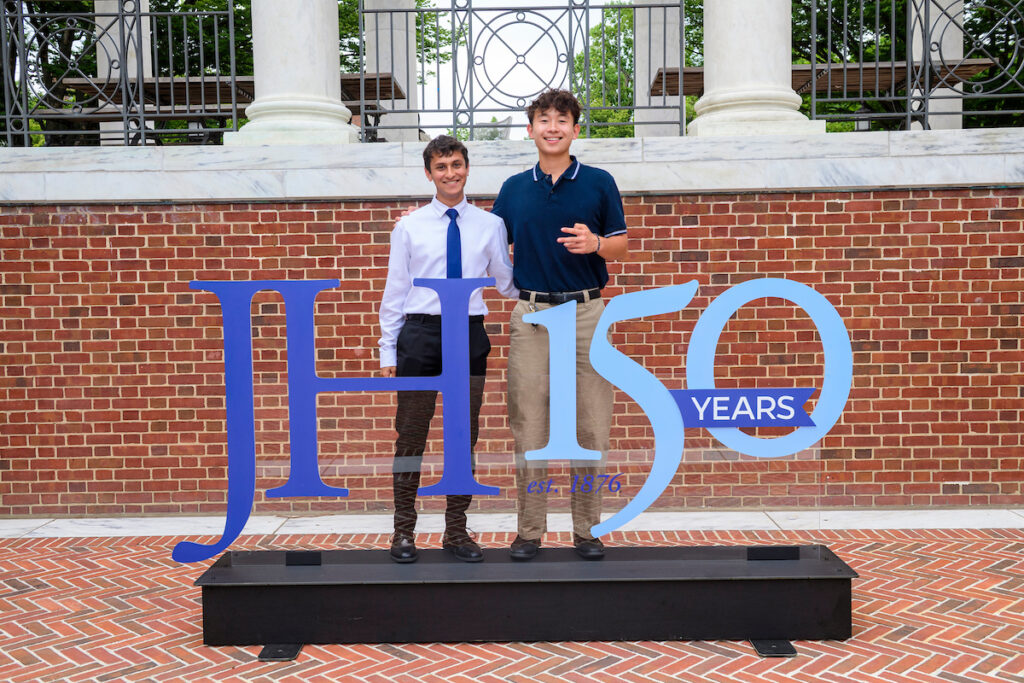 Two students standing behind the JH150 campaign mark 3d