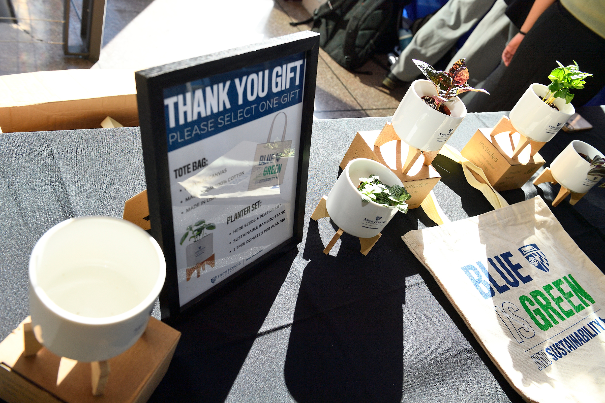 Planter and tote bag giveaways from the Climate and Sustainability department table