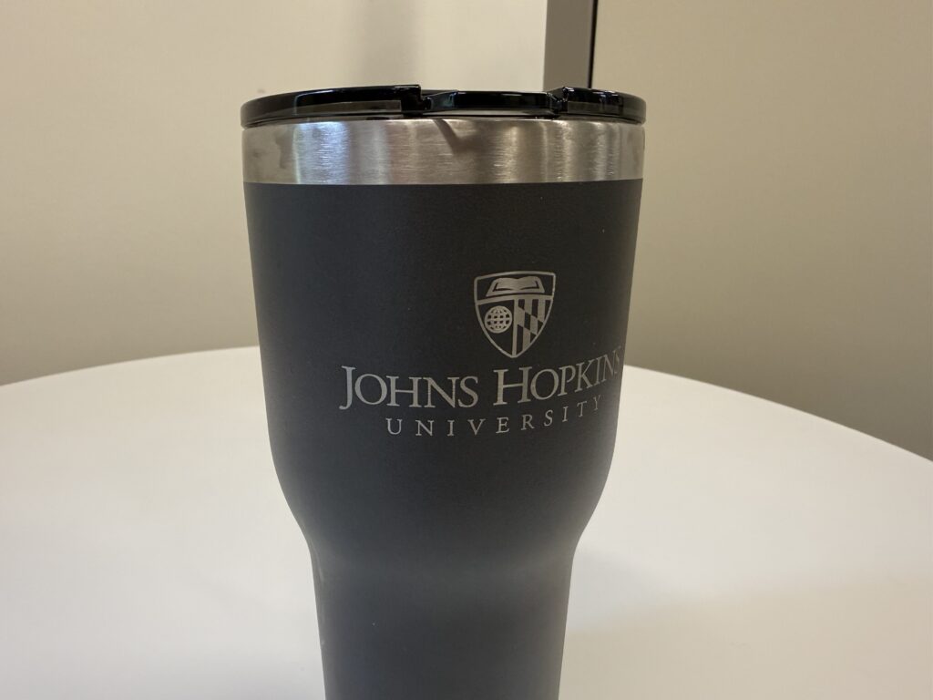 Johns Hopkins University white logo laser engraved on a metal cup
